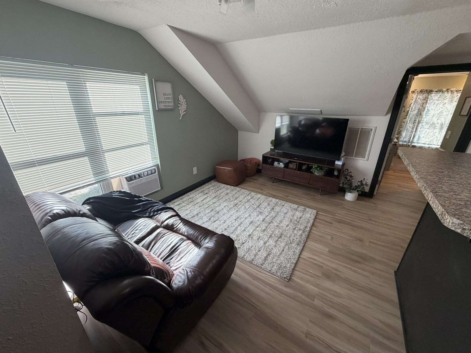 Rose's Barn Loft living room with a leather sofa beneath a vaulted ceiling