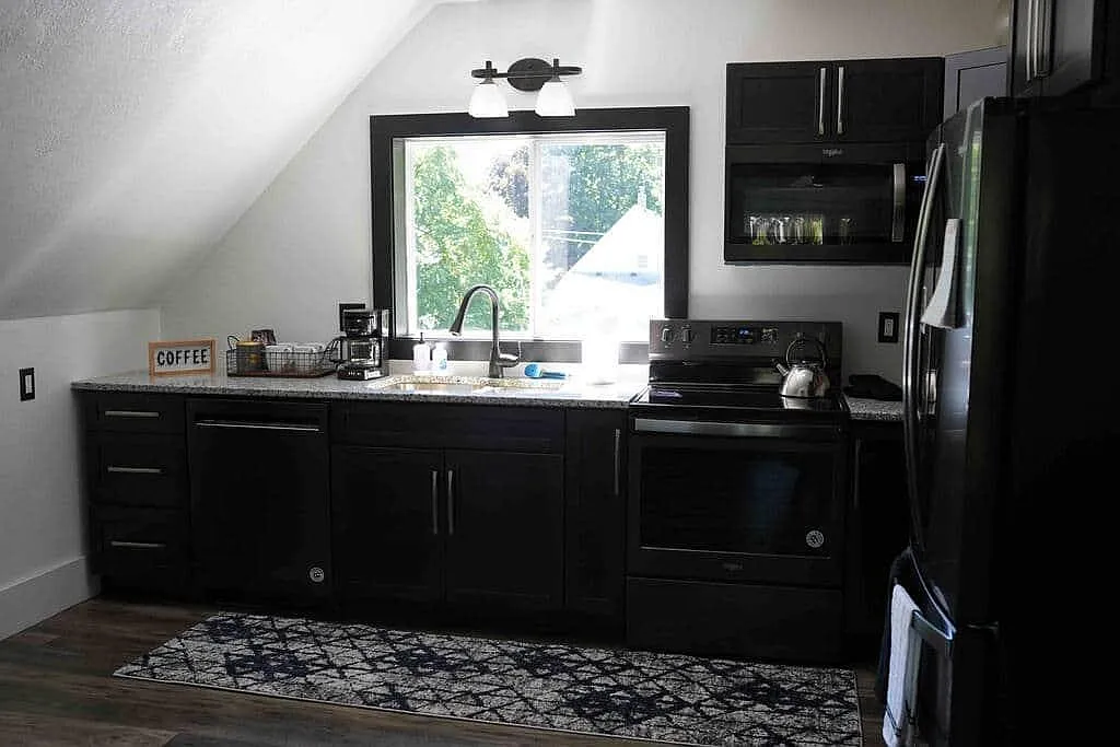Rose's Loft kitchen — black cabinets beneath a vaulted ceiling