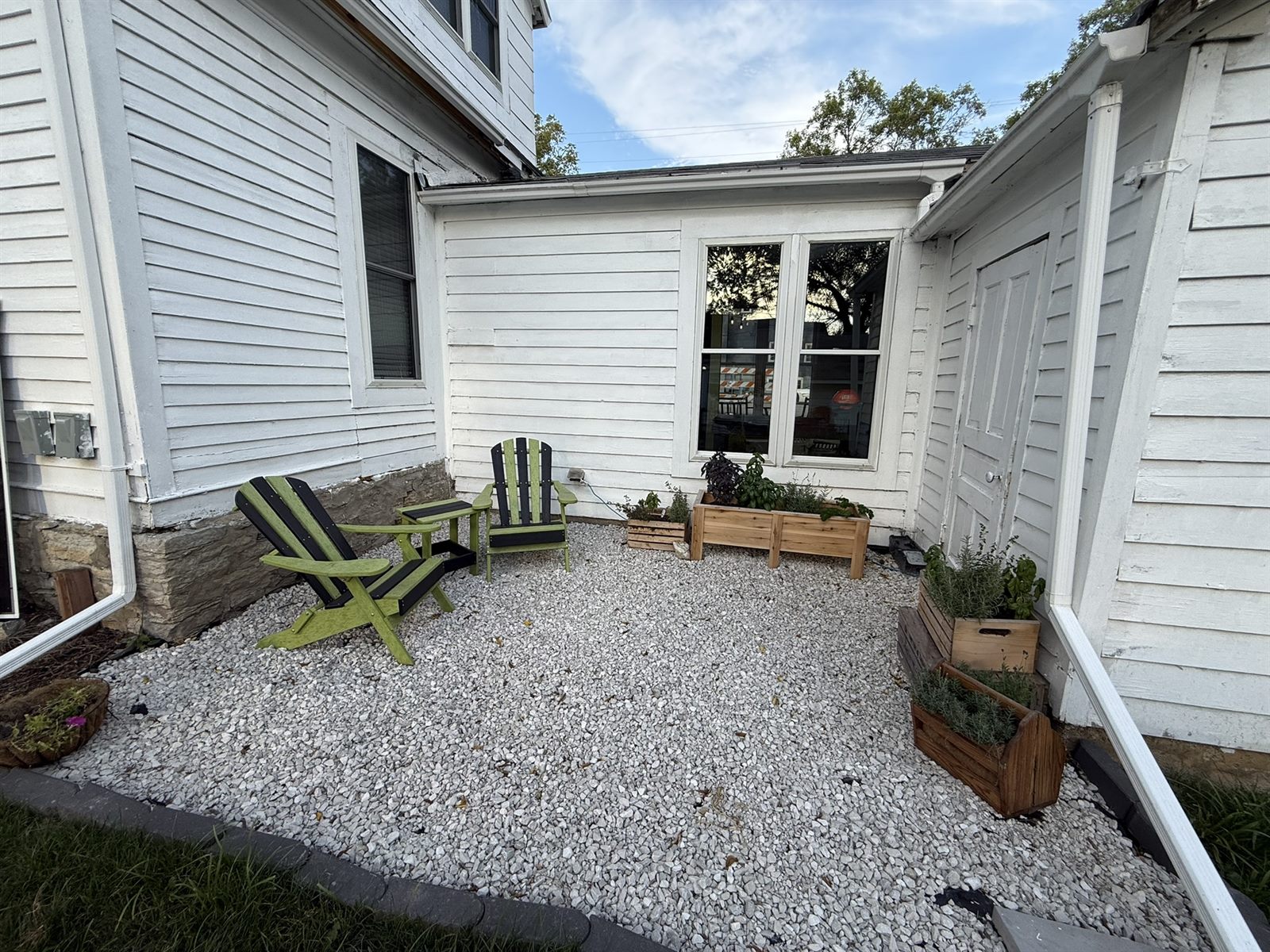 Shared outdoor seating with Adirondack chairs at Rose’s Village